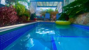 a swimming pool with blue water and plants in a house at Villa De Lasannta - by ZenBreak in Christ Church +14 photos