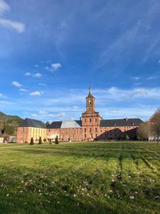 un grande edificio in mattoni con una torre su un campo di Sof tiny a Moyenmoutier