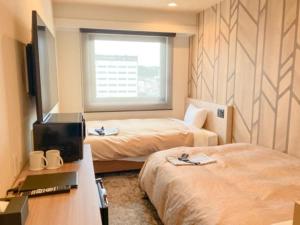 a hotel room with two beds and a window at HOTEL LiVEMAX Toyooka in Toyooka +32 photos