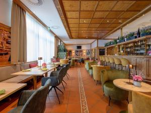Un restaurante con mesas y sillas en una sala. en Mercure Hotel Stuttgart Airport Messe, en Stuttgart