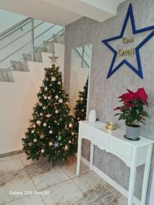 a christmas tree in a living room with a white table at Casa Coresi in Braşov