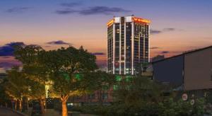 a tall building with red lights on top of it at Vienna Hotel Guiyang Jiaxiulou Jichang Road in Guiyang