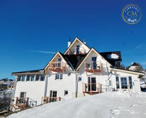 a white house on top of a snowy hill at Carpathia Magic -adults only in Peştera