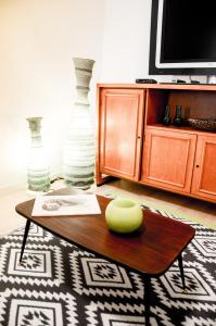 ein Wohnzimmer mit einem Tisch, einem TV und Vasen in der Unterkunft CoreHome in Albano Laziale