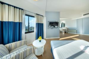 Un dormitorio con una cama, un sofá y una mesa. en Jomtien Palm Beach Hotel and Resort, en Jomtien Beach