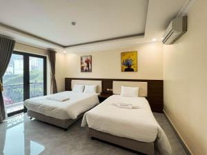 una camera d'albergo con due letti e una finestra di TGlobal Quynh Hoa Tam Dao a Tam Ðảo