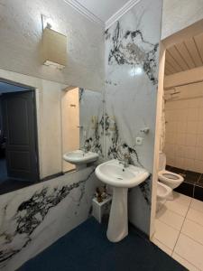 a bathroom with two sinks and a toilet in it at BT City Hotel in Gornyy Gigant +62 photos