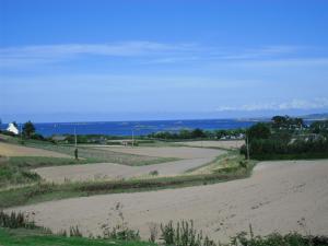 an empty dirt road with the ocean in the background at maison kerivarch G in Saint-Pol-de-Léon