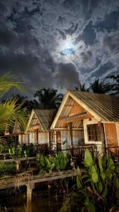 a group of houses with the moon in the sky at ปารมีฟาร์มสเตย์ in Ban Chao Nam