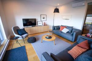 un salon avec un canapé et une table dans l'établissement Luxury Condo on the Riverfront with Terrace, à Baie-Saint-Paul