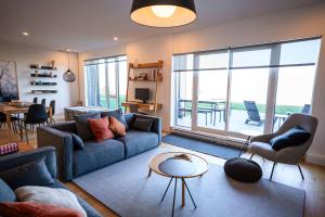 un salon avec un canapé et une table dans l'établissement Luxury Condo on the Riverfront with Terrace, à Baie-Saint-Paul