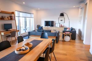 un salon avec un canapé bleu et une table dans l'établissement Luxury Condo on the Riverfront with Terrace, à Baie-Saint-Paul 40 autres photos