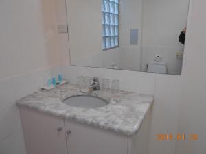 uma casa de banho com um lavatório em mármore e um espelho. em Harringtons102 em Hobart
