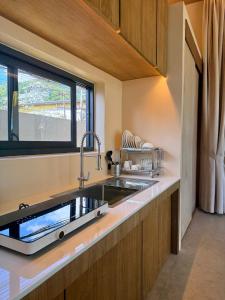 a kitchen with a sink and a window at Samui Garden Home in Lamai
