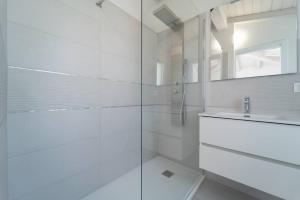 un bagno bianco con doccia e lavandino di Luxi by NG Collection a Olbia Altre 14 foto