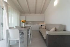 una cucina e un soggiorno con un tavolo e un divano di Luxi by NG Collection a Olbia