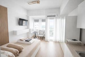 a white room with a bed and a table at Ignis by KolivHub I Studio I Sentul in Kedungmanggu