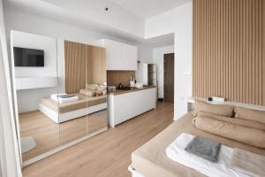 a large white room with a bed and a kitchen at Ignis by KolivHub I Studio I Sentul in Kedungmanggu