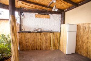 lodówka w pokoju z drewnianą ścianą w obiekcie The Pallet - Guest House w mieście Santa Cruz
