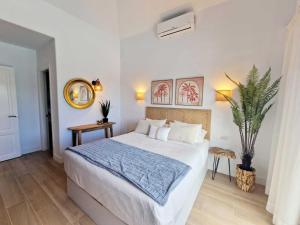 a bedroom with a bed and a potted plant at Costa Christina con piscina climatiza in Yaiza