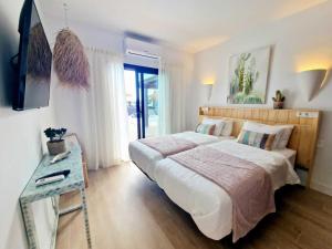 a bedroom with a large bed and a table at Costa Christina con piscina climatiza in Yaiza