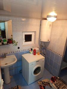 ein Badezimmer mit Waschmaschine und Waschbecken in der Unterkunft Гостевой дом Куттуу Кол in Kichi-Jargylchak