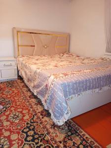ein Schlafzimmer mit einem Bett und einem Teppich auf dem Boden in der Unterkunft Гостевой дом Куттуу Кол in Kichi-Jargylchak