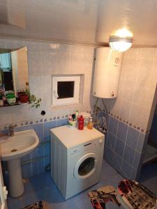 ein Badezimmer mit Waschmaschine und Waschbecken in der Unterkunft Гостевой дом Куттуу Кол in Kichi-Jargylchak
