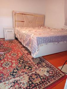 ein Schlafzimmer mit einem Bett und einem großen Teppich in der Unterkunft Гостевой дом Куттуу Кол in Kichi-Jargylchak