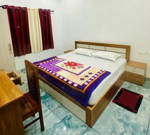 a bedroom with a bed with a colorful quilt on it at Zonooro Homestay Vythiri in Vythiri
