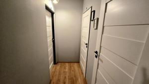a hallway with a closet with white cabinets and a wooden floor at 4 Lions Guest House in Gdańsk