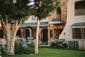 a house with trees and flowers in the yard at Tuscany Vryburg in Vryburg