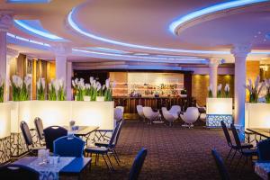 ein Speisesaal mit Tischen und Stühlen und einer Bar in der Unterkunft Hotel Windsor w Jachrance in Jachranka