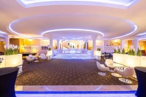 eine Hotellobby mit weißen Stühlen und einer Treppe in der Unterkunft Hotel Windsor w Jachrance in Jachranka