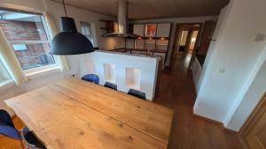 una cucina e una sala da pranzo con tavolo e sedie in legno di Villa Henneby a Henne