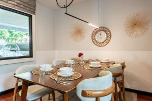 una sala da pranzo con tavolo e sedie in legno di Bangkok Cozy Garden Pool Villa Sukhumvit a Amphoe Phra Khanong
