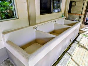 a white bath tub sitting under a window at DW Motel in Koror