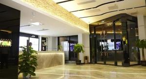 a lobby with glass doors and plants in a building at LAVANDE Hotel Dalian Huanan Square North Railway Station in Dalian