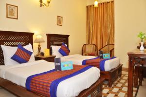 a hotel room with three beds with certificates on them at Rajputana Haveli in Jaipur