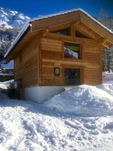 una baita di tronchi con neve di fronte di Vieux Zinal a Zinal