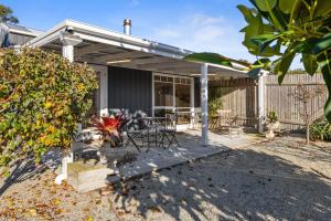 a house with a patio with a table and chairs at Wombat Pavilion in Yanakie