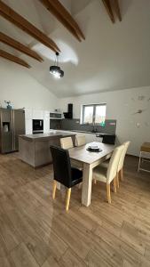 a dining room with a table and chairs and a kitchen at Apartmán 135 in Trutnov