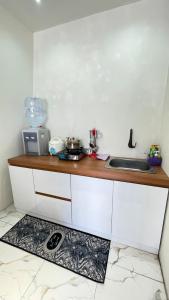 a kitchen with a counter with a sink and a kitchen rug at Villa Celyn Dieng2 in Diyeng