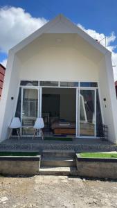 a white house with two chairs on a patio at Villa Celyn Dieng2 in Diyeng