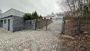 a gate on a brick driveway with a house at Apartmán 135 in Trutnov