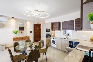 a kitchen and dining room with a glass table and chairs at Stylish 2BR Retreat, Central Location, Few Steps from the Sea by QuickTrips in Marsaskala +36 photos