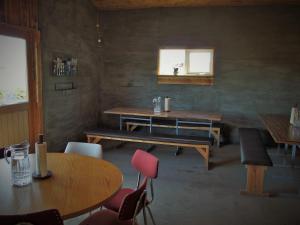 a dining room with tables and chairs and a window at Saltvík Farm Guesthouse in Húsavík
