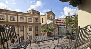 a balcony with a table and chairs and buildings at Echarm Hotel Jinan Railway Station Daming Lake in Jinan