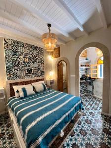 een slaapkamer met een groot bed in een kamer bij Riad dar el hania in Essaouira +27 foto's
