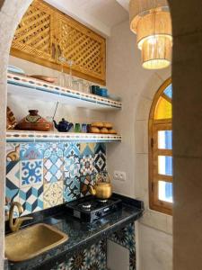 een keuken met een fornuis en een aanrechtblad bij Riad dar el hania in Essaouira